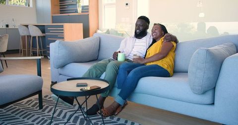 Couple Relaxing on Sofa with Coffee at Home
