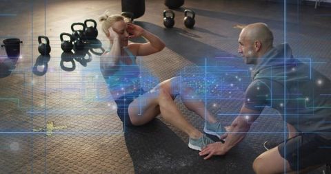 Female athlete doing sit-ups with coach holding feet and digital hud fitness overlay