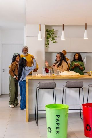 Multigenerational african american family cooking and recycling together in modern kitchen