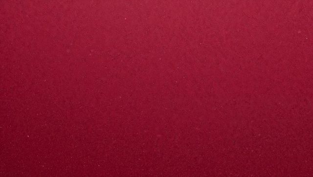 Burgundy paper texture showing subtle grain and tiny flecks for background use