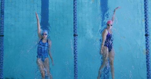 Competitive swimmers practicing backstroke in swimming pool