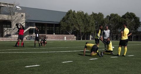 Soccer Team Practicing on Grass Field with Coach Guidance