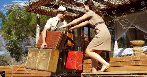 Couple carrying vintage suitcases on safari deck adventure