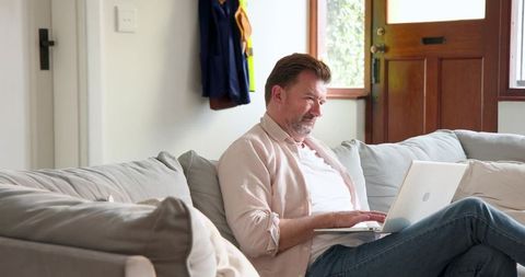 Man working from home on laptop in cozy living room