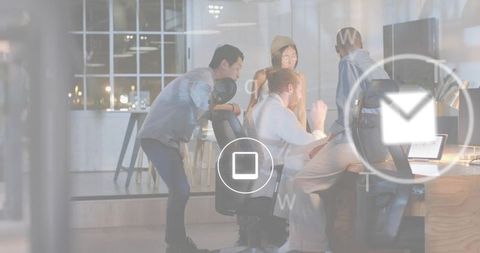 Young team collaborating around laptop with ui icons overlay in modern open-plan office