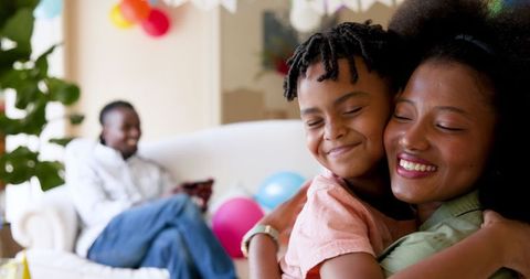 Happy Family Celebrating Son's Birthday at Home with Joyful Hugs