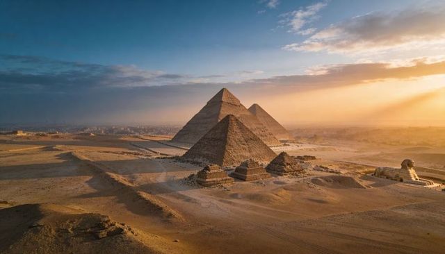 Giza pyramids and great sphinx glowing in golden hour aerial panorama over desert and cairo skyline