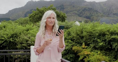 Elderly Woman Relaxing and Taking Selfie with Wine in Scenic Outdoors