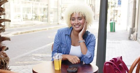 Young Woman Enjoying Drink at Outdoor Cafe