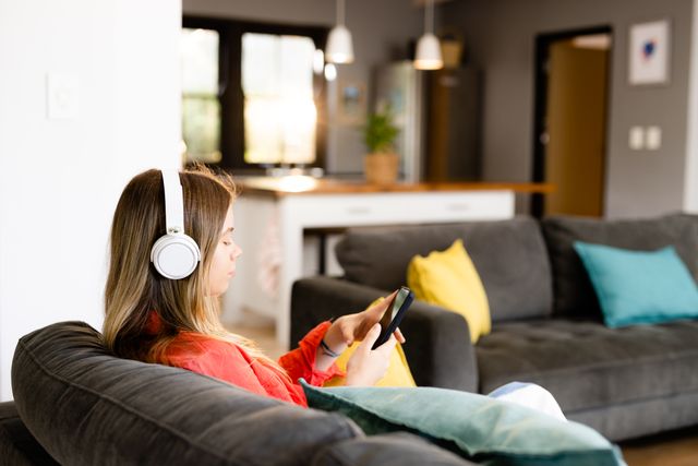 Teenage Girl Relaxing on Couch with Headphones and Smartphone - Download Free Stock Images Pikwizard.com