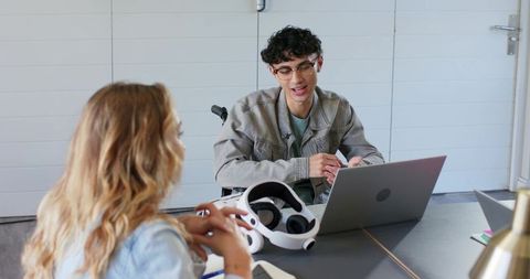 Inclusive workplace collaboration with vr headset and wheelchair at modern meeting table