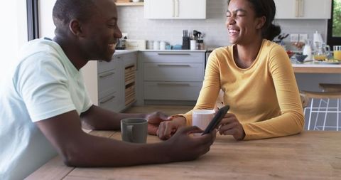 Joyful African American Couple Enjoying Coffee and Quality Time in Kitchen