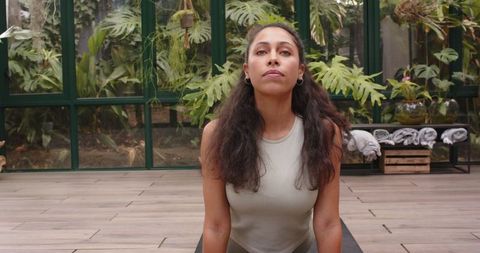 Woman Practicing Yoga Upward Dog Pose in Greenhouse