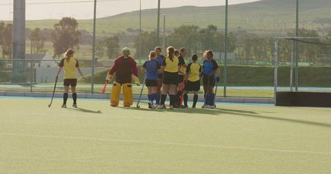 Female Field Hockey Players Strategizing During Outdoor Game