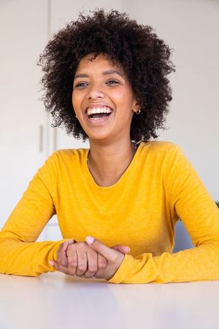 Joyful African American Woman Laughs in Modern Kitchen