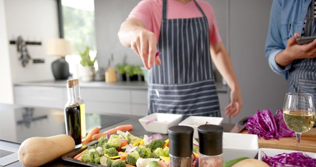 Man Seasoning Vegetables in Modern Kitchen with Partner - Download Free Stock Images Pikwizard.com