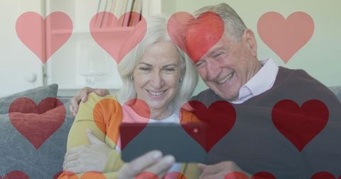 Senior Couple Enjoying Smartphone with Heart Social Media Icons