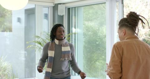 Diverse Male Friends Conversing in Bright Modern Living Room with Scarf and Brown Jacket