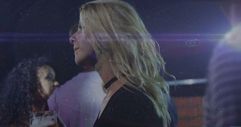 Blonde Woman Enjoying Nightlife and Socializing at Bar