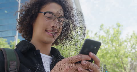 Young Man Interacting with Mobile Device and Digital Face Overlay
