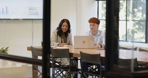 Coworkers Collaborating on a Laptop in Stylish Modern Office