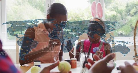 Guiding child painting easter eggs at home with bunny ears and digital world overlay