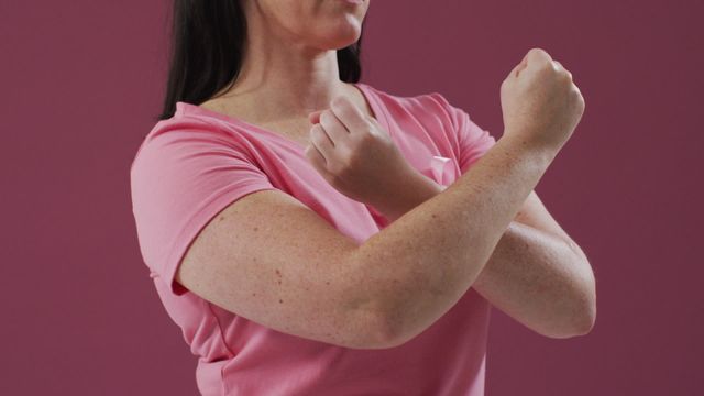 A woman wearing pink ribbon on her chest with arms crossed in a stop sign gesture. This represents breast cancer awareness, vital for educational health campaigns. Ideal for use in health advocacy materials, informational flyers, social media posts supporting breast cancer initiatives, or educational articles promoting awareness and prevention campaigns.