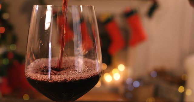 Red wine pouring into glass on wooden table during christmas time 4k