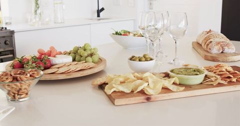 Elegant spread of snacks and wine glasses in modern kitchen