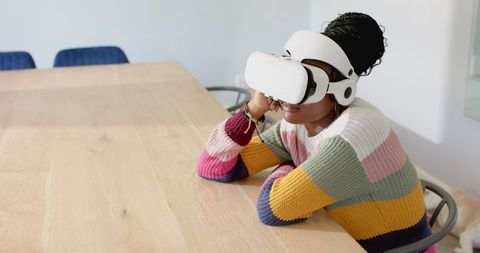 Woman experiencing virtual reality at table