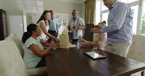 Diverse Senior Group Exchanging Gifts at Home Celebration