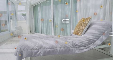 Sunlit sunroom with white daybed and gray quilted cover