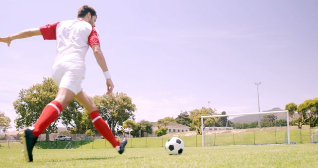 Football player kicking the ball on the football ground