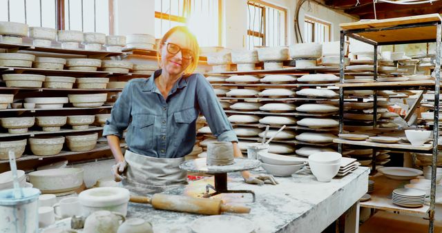 Female Potter in Studio Smiling Confidently with Pottery Wheel and Finished Ceramics - Download Free Stock Images Pikwizard.com