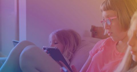 Sisters Relaxing at Home Using Smartphones