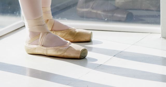 Legs of caucasian female ballet dancer in pointe shoes with copy space. Ballet, dance, movement and lifestyle concept, unaltered.