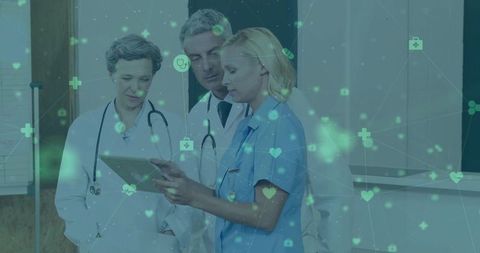 Medical team reviewing digital patient data in clinic corridor