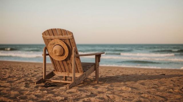 Wooden Beach Chair with Sunhat Overlooking Ocean Waves for Serene Leisure