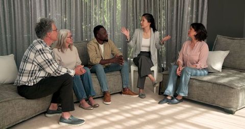 Diverse Group Engaged in Therapy Session Discussion Indoors