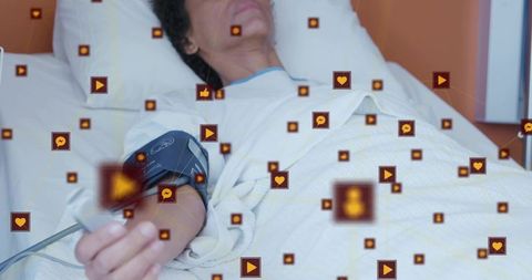 Woman receiving vital sign monitoring with blood pressure cuff and telemetry overlay