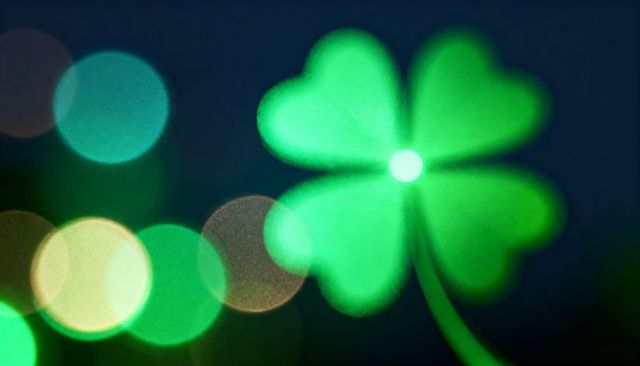 Glowing four-leaf clover with bokeh lights, emerald shamrock abstract background