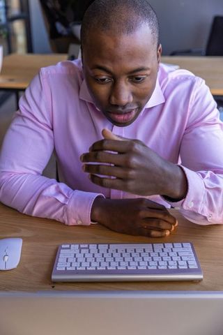 Business Professional Typing on Wireless Keyboard in Modern Workspace