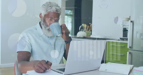 Man Analyzing Data on Laptop with Coffee in Hand