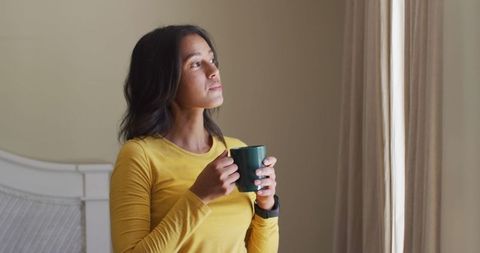 Contemplative Woman with Coffee in Morning Light at Home