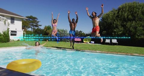Friends jumping into backyard pool on sunny summer day wearing colorful swimwear
