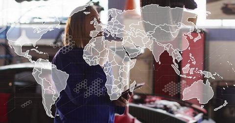 Female mechanic using tablet for vehicle diagnostics with world map tech overlay