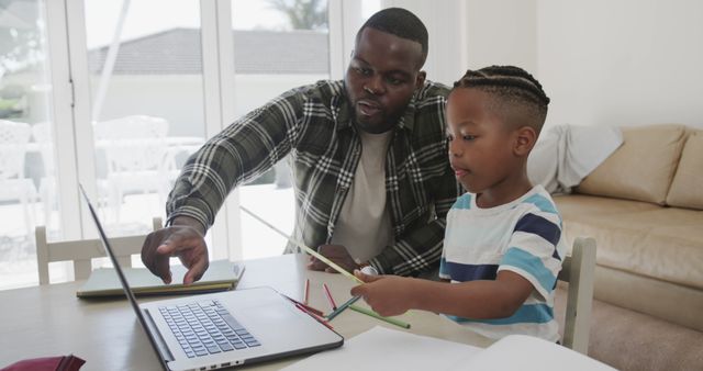 Father Helping Son with Homeschooling Using Laptop in Living Room - Download Free Stock Images Pikwizard.com