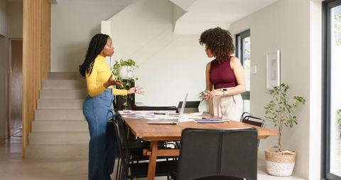 Black Women Collaborating on Home Design Planning with Laptop and Fabric Swatches