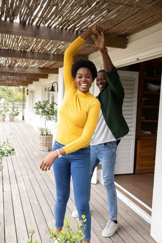 Joyful African American Couple Dancing on Sunlit Veranda