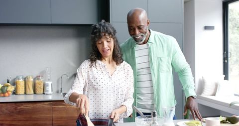Happy Biracial Couple Cooking in Modern Kitchen